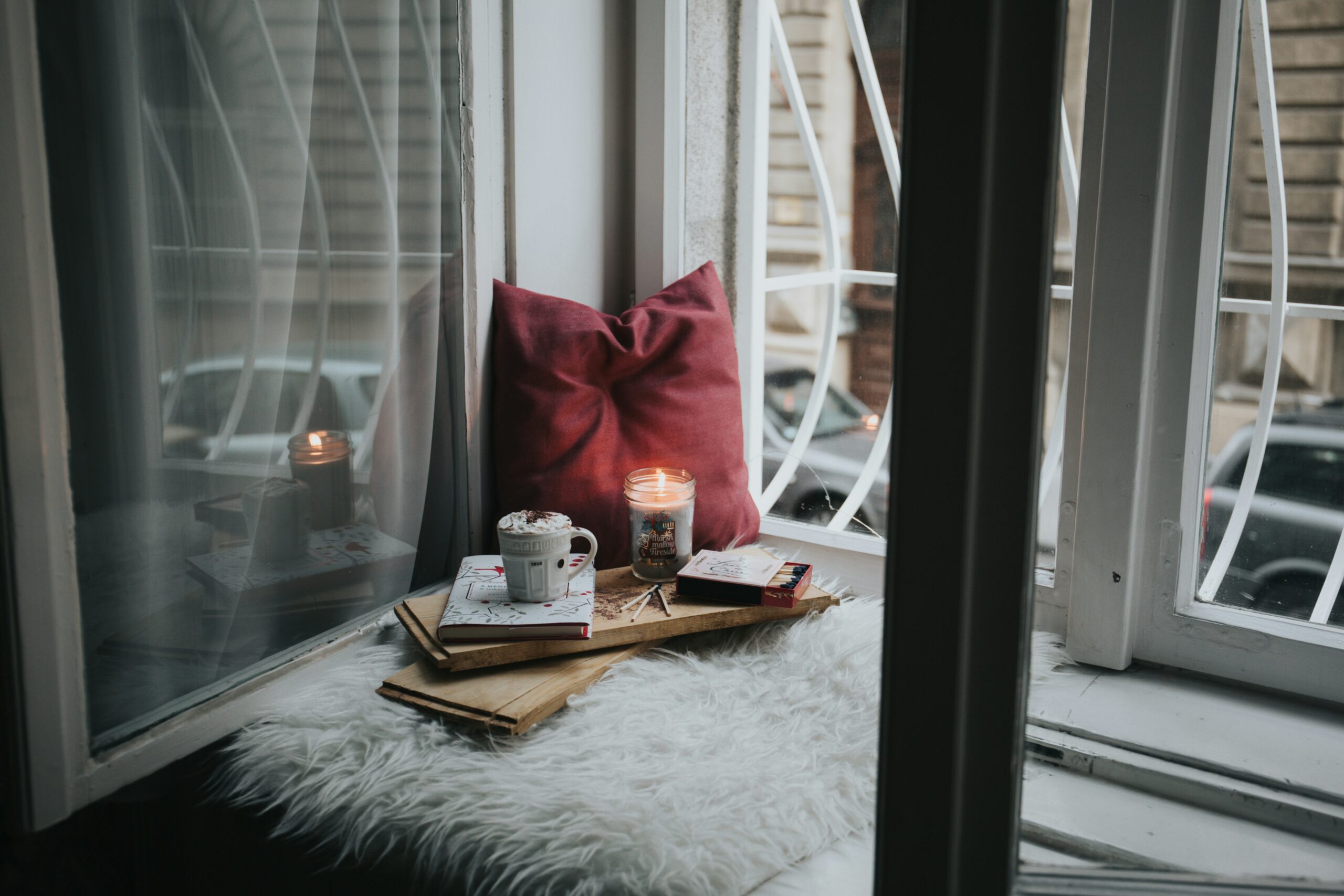 cosy reading corner with mug of tea, candle and pillow